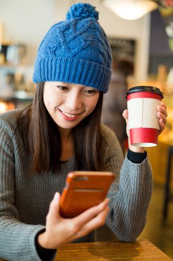 Cep telefonu kafede kullanan kadın