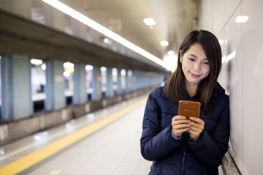Yeraltı metro istasyonuna cep telefonu kullanan kadın