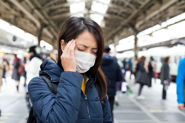 Жінка в масці для обличчя на залізничній станції — стокове фото