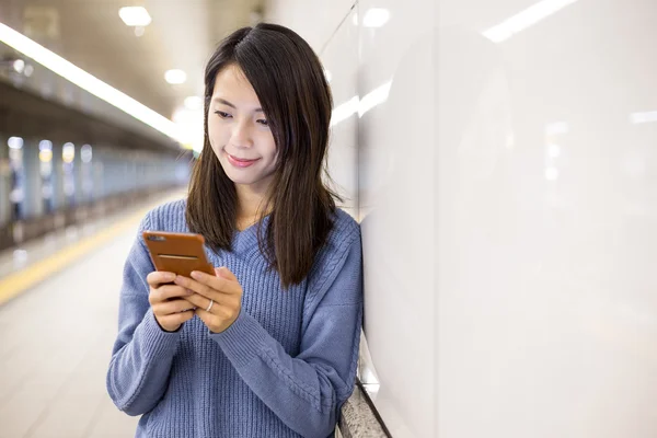 Жінка використовує мобільний телефон на станції метро — стокове фото
