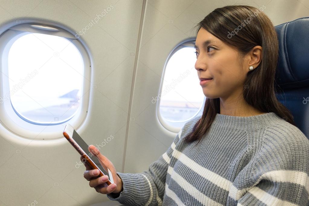 woman using cellphone inside airplane