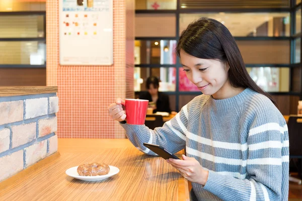 kahve dükkanında cep telefonu kullanan kadın
