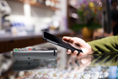 Fatura ödeme için cep telefonu kullanan kadın