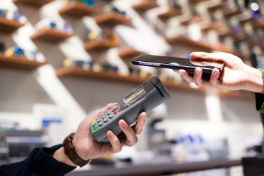 Fatura ödeme için cep telefonu kullanan kadın