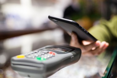 Fatura ödeme için cep telefonu kullanan kadın