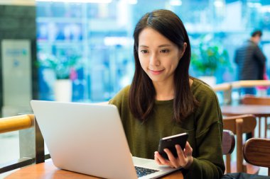 cep telefonu ve dizüstü bilgisayar kullanan kadın