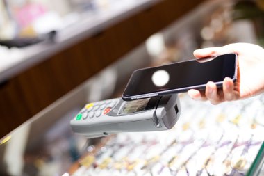 Fatura ödeme için cep telefonu kullanan kadın