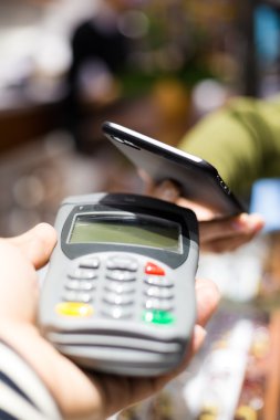 Fatura ödeme için cep telefonu kullanan kadın