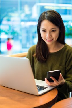 cep telefonu ve dizüstü bilgisayar kullanan kadın