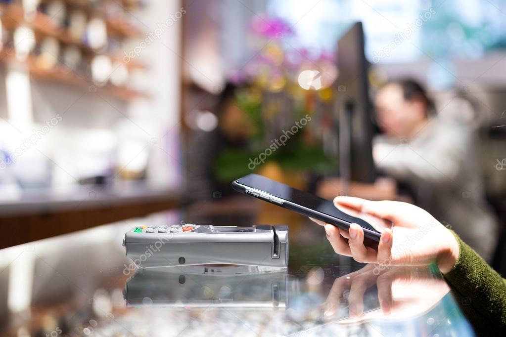 Woman using cellphone for paying the bill