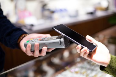 Fatura ödeme için cep telefonu kullanan kadın
