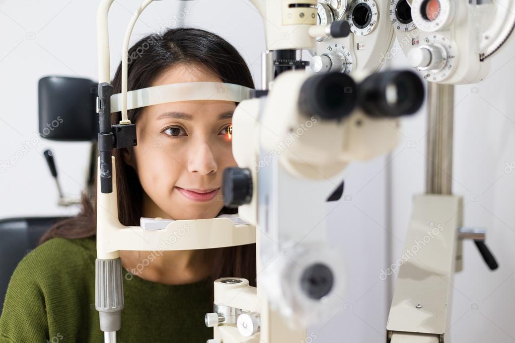 Woman checking vision at eye clinic