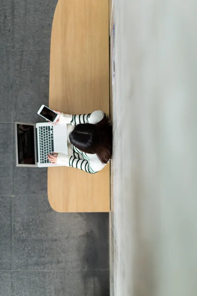 Vrouw met behulp van slimme telefoon en laptop — Stockfoto