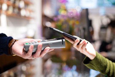 Fatura ödeme için cep telefonu kullanan kadın