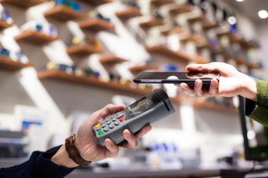 Fatura ödeme için cep telefonu kullanan kadın