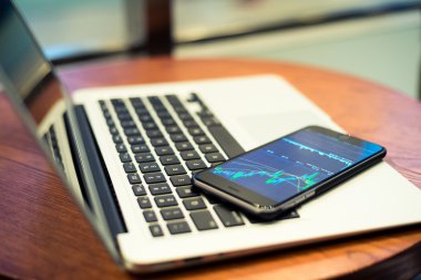 Smartphone ile borsa grafik bir ekran üzerinde 