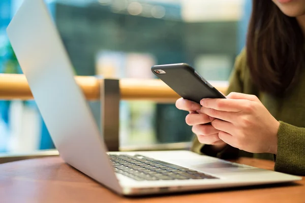 Mujer usando teléfono móvil y portátil — Foto de Stock