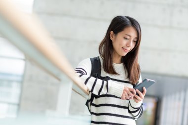 Asyalı öğrenci cep telefonu kullanarak