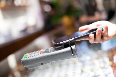 Fatura ödeme için cep telefonu kullanan kadın