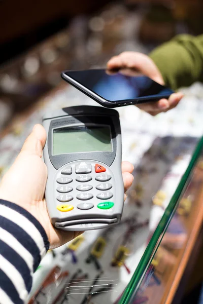 Woman using cellphone for paying the bill — Stock Photo, Image