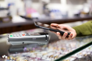 Fatura ödeme için cep telefonu kullanan kadın