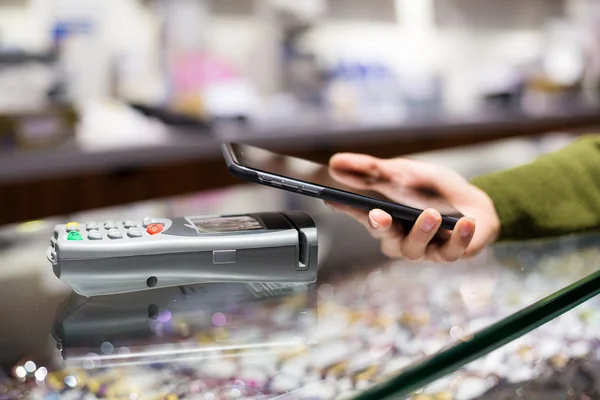 Mujer usando el teléfono celular para pagar la factura — Foto de Stock