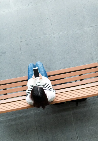 Žena na lavičce pomocí mobilního telefonu — Stock fotografie