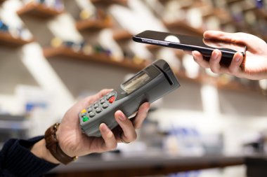 Fatura ödeme için cep telefonu kullanan kadın