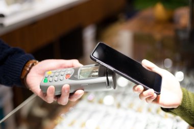 Fatura ödeme için cep telefonu kullanan kadın