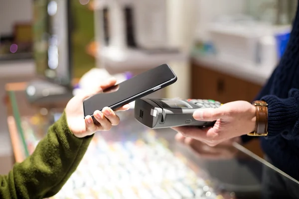 Woman using cellphone for paying the bill — Stock Photo, Image