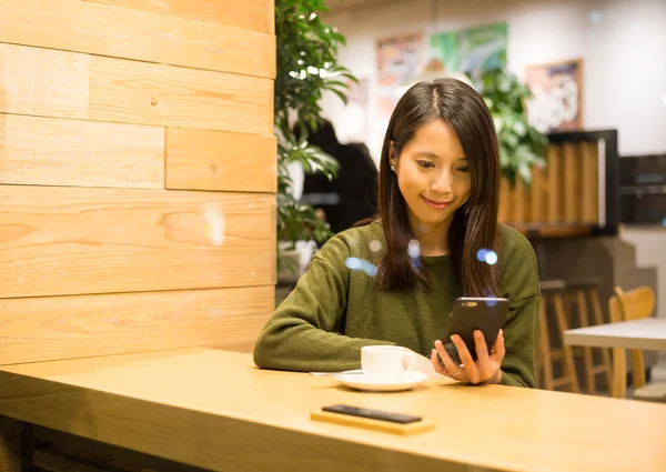 Женщина с помощью смартфона в кафе — стоковое фото