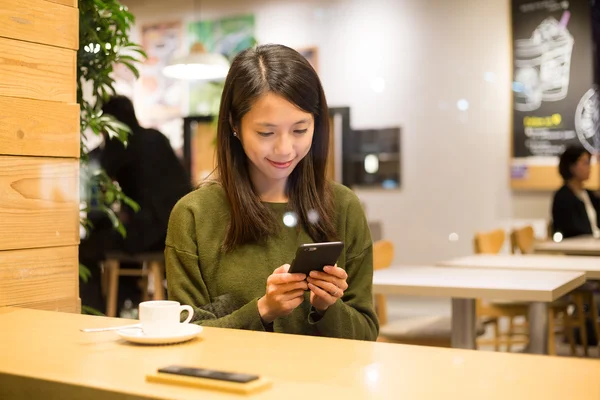 Kahve dükkanında akıllı telefon kullanan kadın — Stok fotoğraf
