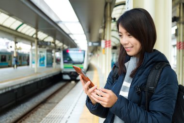 Tren istasyonunda cep telefonu kullanan kadın