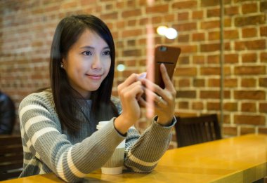 kahve dükkanında akıllı telefon kullanan kadın