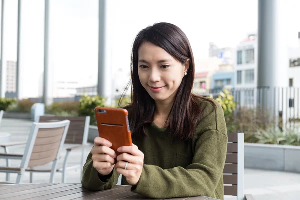 Kobieta za pomocą telefonów komórkowych w kawiarni — Zdjęcie stockowe