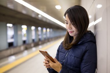 Metro istasyonuna cep telefonu kullanan kadın