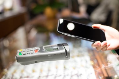 Fatura ödeme için cep telefonu kullanan kadın