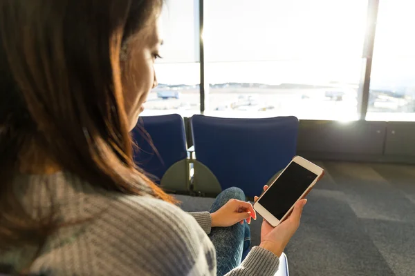 Mulher usando telefone celular no corredor de partida no aeroporto — Fotografia de Stock