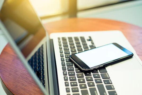 Laptop computer and cellphone on table — Stock Photo, Image