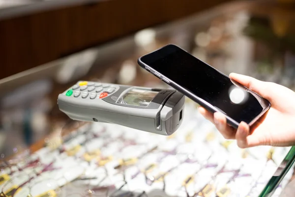 Vrouw met behulp van de mobiele telefoon voor het betalen van de rekening — Stockfoto