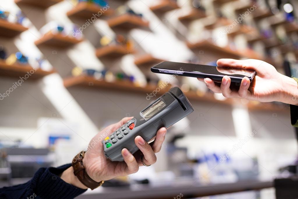 Woman using cellphone for paying the bill