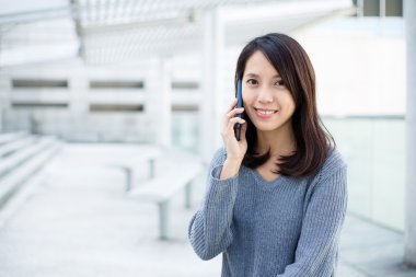 Kadın cep telefonuyla konuşuyor.