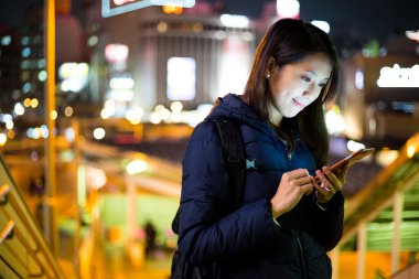 Akşamları akıllı telefon kullanan kadın. 