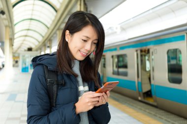 tren istasyonunda cep telefonu kullanan kadın