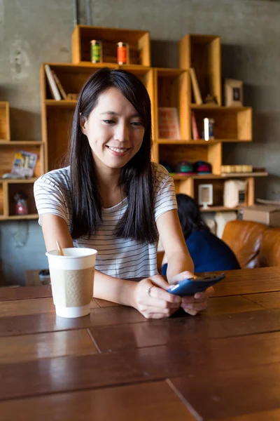 Жінка насолоджується кавою і використовує мобільний телефон — стокове фото