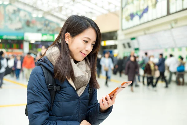 tren istasyonunda cep telefonu kullanan kadın