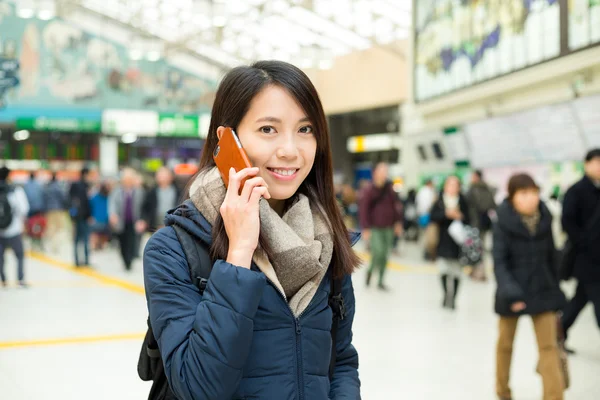 Kvinnan pratar på mobiltelefon train station — Stockfoto
