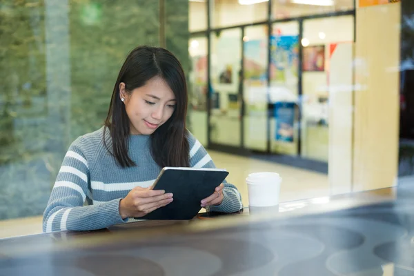 Vrouw met behulp van digitale tablet in koffie winkel — Stockfoto