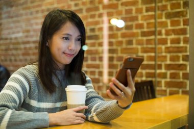 kahve dükkanında cep telefonu kullanan kadın  