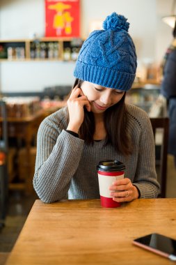 Kafede elinde kahve fincanı olan kadın.